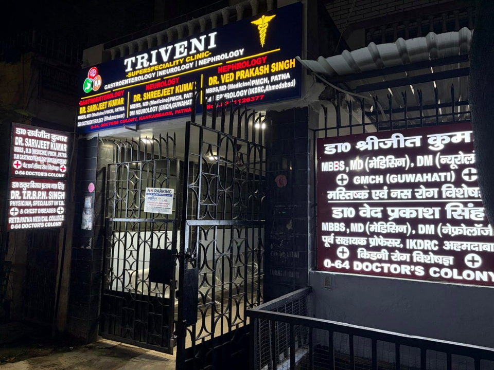 Triveni Superspeciality Clinic entrance and illuminated signage at night.